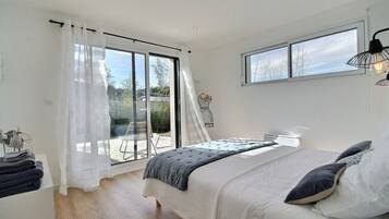 Een slaapkamer met een bed, een raam en uitzicht op de omgeving.