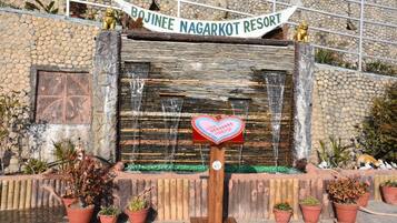 Señal del Resort Bujanee Nagarkot, con un buzón con forma de corazón y plantas en macetas al frente.