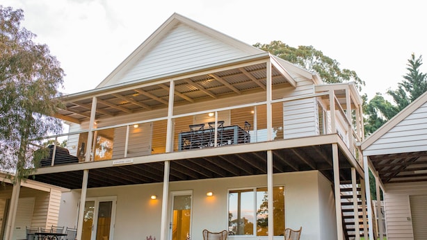 A two-story house with a covered patio, a balcony, and a garage. - McMillans of Metung Coastal Resort (Metung)