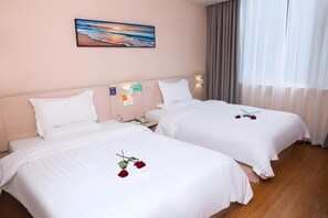 Habitación de hotel con dos camas, un cuadro en la pared y una ventana con cortinas.