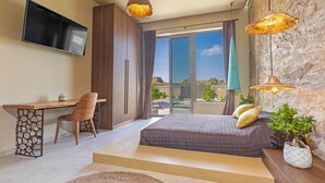 A modern bedroom with a bed, desk, chair, TV, and large windows.