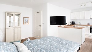 Une chambre à coucher moderne avec un lit, une armoire et un téléviseur.