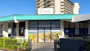 A beachfront bar and grill named 'Oceans' with a view of the sea through large windows. - SanDBeach Villa, Edgewater Villa 3302-1st Floor-2 Patios-2 Bd/2Ba-Free Sandy Beach Tram! (Panama City Beach)