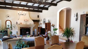 A spacious living room with a fireplace, wooden furniture, and various decorative items.