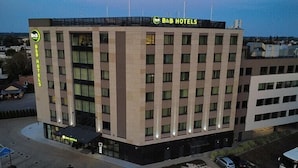 A B&B hotel building with a modern design, featuring multiple floors and a prominent B&B Hotels sign on the roof. - B&B HOTEL Warsaw East (Warsaw)