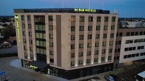 A B&B hotel building with a modern design, featuring multiple floors and a prominent B&B Hotels sign on the roof. - B&B HOTEL Warsaw East (Warsaw)