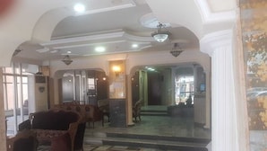 A lobby with patterned flooring, a sofa, and a staircase leading to another area. - Universal Residence (Beirut)