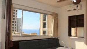 A room with a large window, a ceiling fan, and a built-in shelf. - Universal Residence (Beirut)