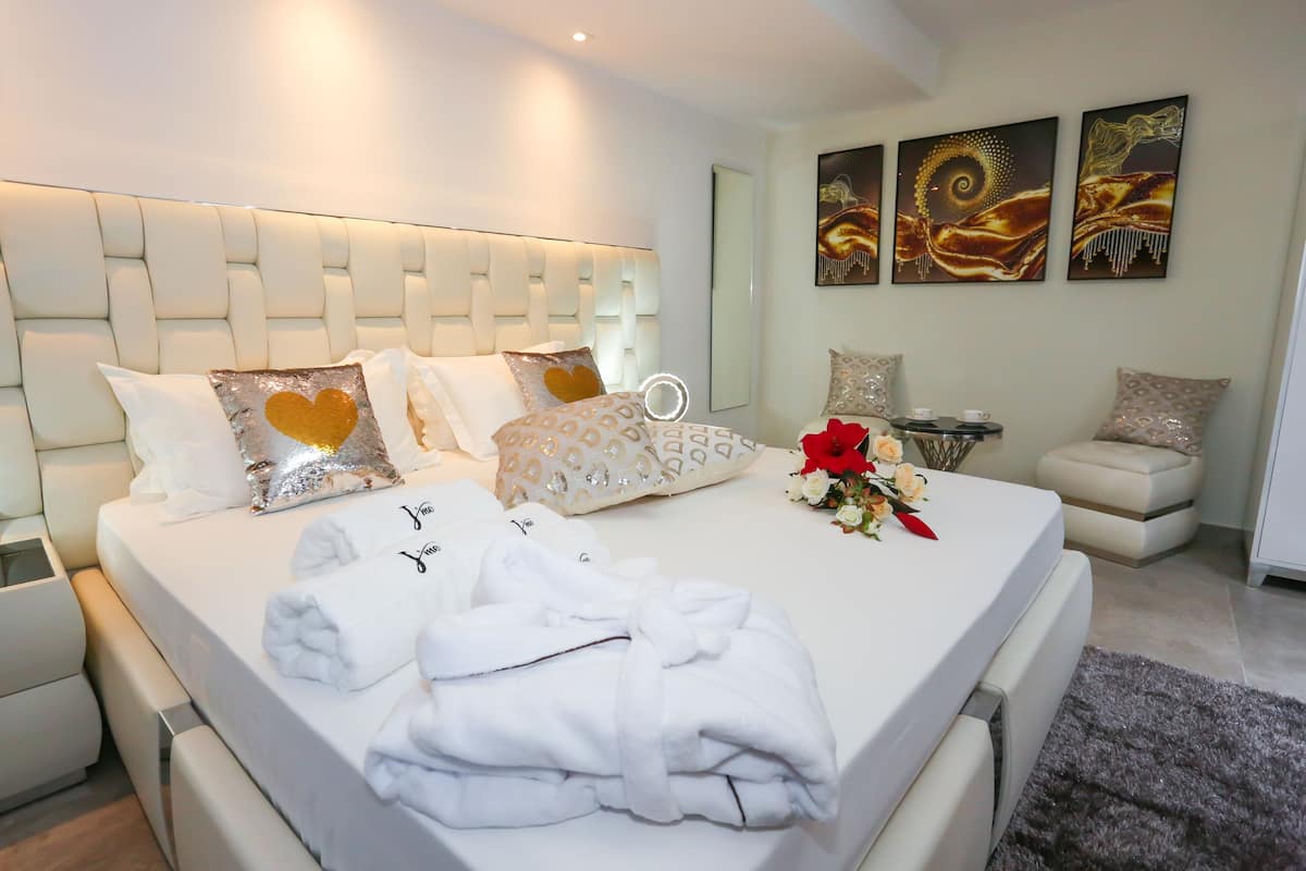 Ein modernes Hotelzimmer mit einem großen Bett, einem Nachttisch und einer kleinen Sitzecke.