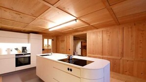 Una cocina moderna con paneles de madera, una isla central con pileta y electrodomésticos integrados.