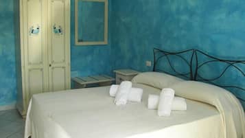 Quarto com cama, mesa de cabeceira, cômoda e espelho.