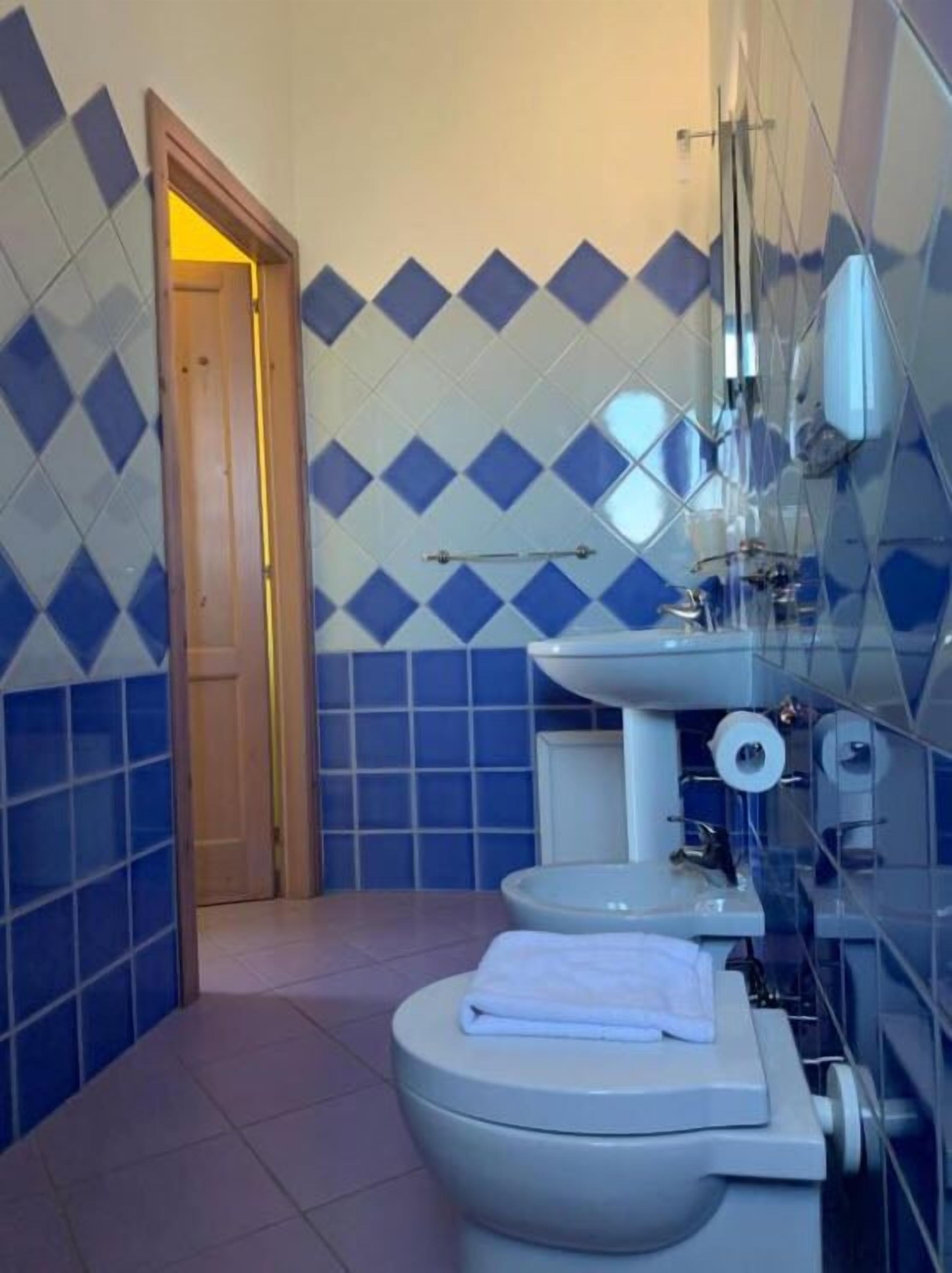 Un baño con inodoro, lavabo y espejo.