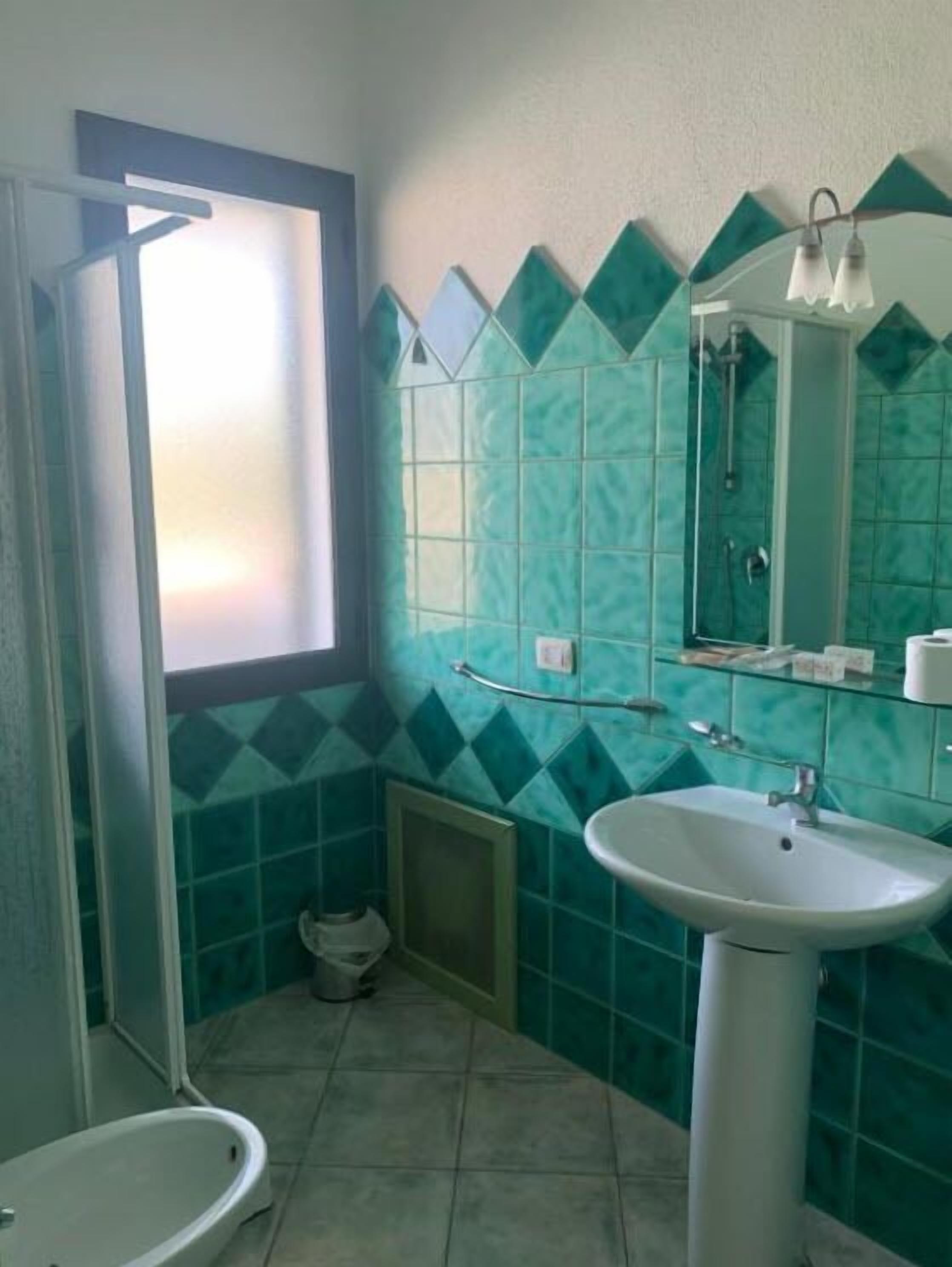 A bathroom with a shower, a sink, and a toilet.