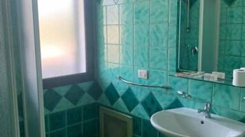 A bathroom with a shower, a sink, and a toilet.