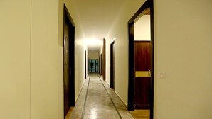 Un long couloir étroit, avec des portes des deux côtés, donnant accès à différentes pièces.