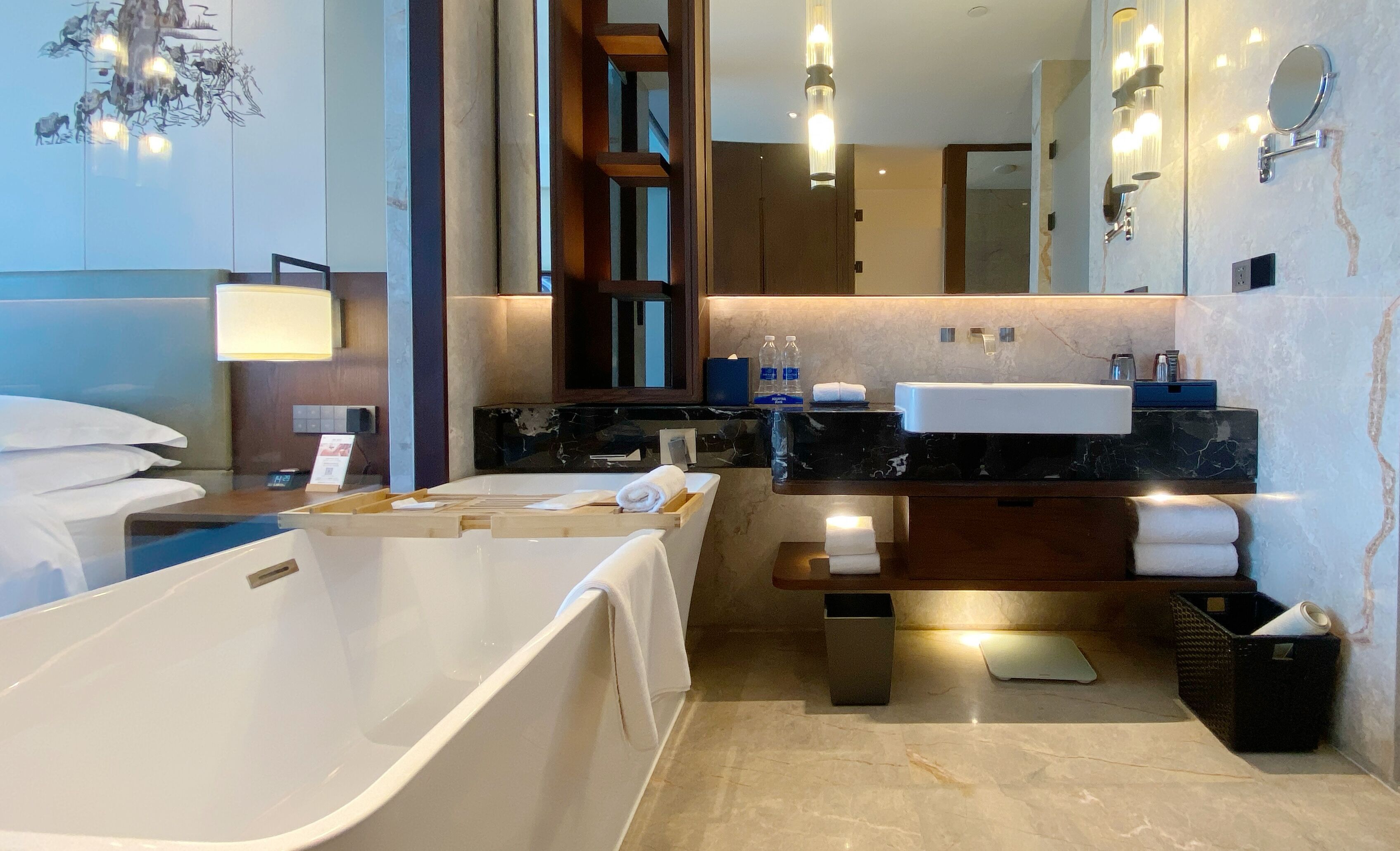A modern bathroom with a bathtub, a vanity with a mirror, and a shower area.