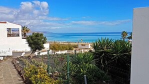 Une vue sur la côte, avec un bâtiment blanc, un chemin pavé et un jardin clos.