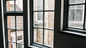 Three windows with a view of brick buildings outside. - 16 Queen Avenue (Liverpool)