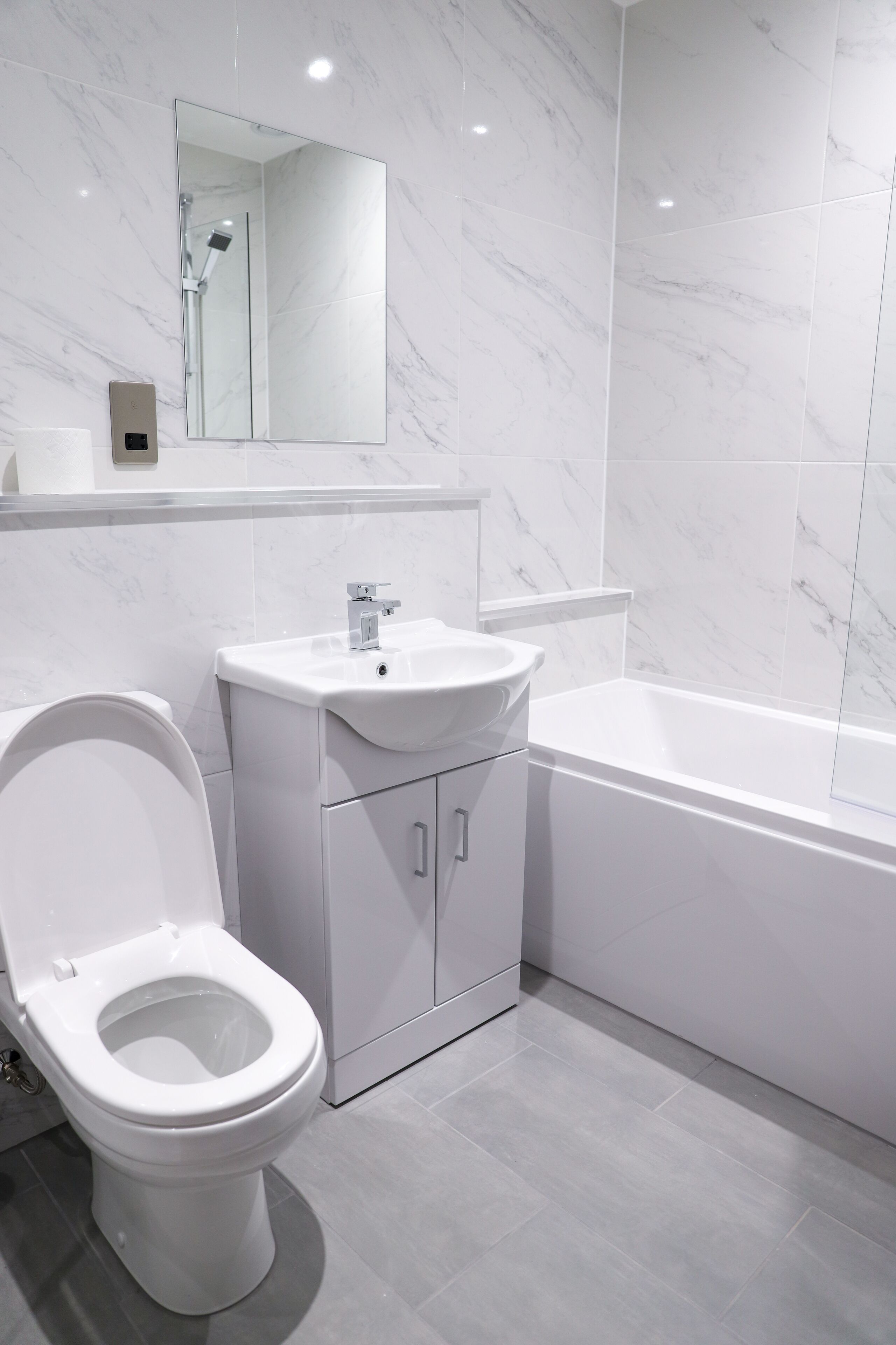 Un baño moderno con inodoro, lavamanos y bañera.