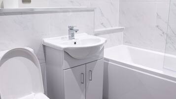 Un baño moderno con inodoro, lavamanos y bañera.