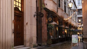 A narrow street with historic buildings, a wooden door, and a signboard. - 16 Queen Avenue (Liverpool)