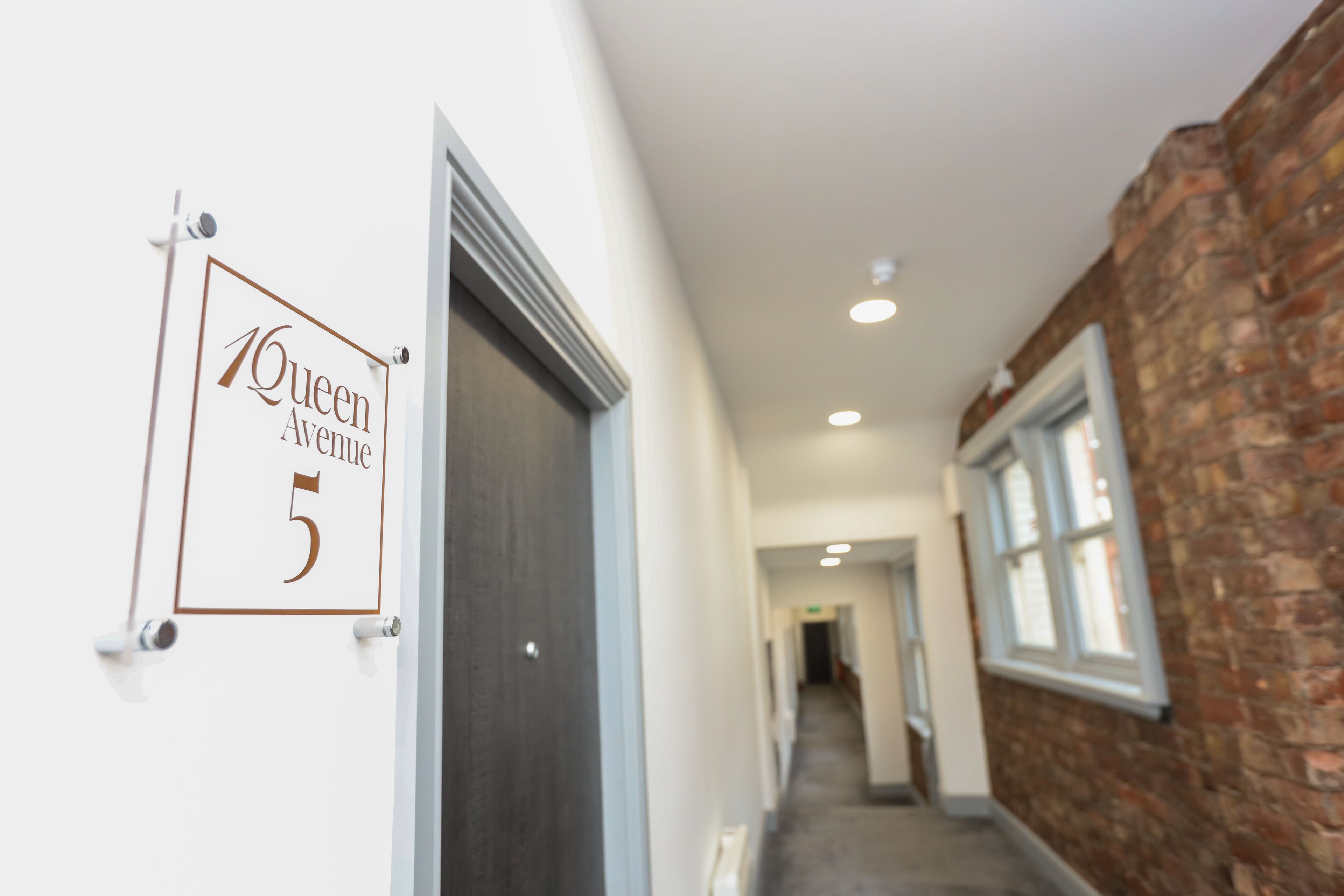 A hallway with a sign reading "Queen Avenue 5".