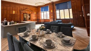A dining area with a marble table set for four, surrounded by upholstered chairs. - 16 Queen Avenue (Liverpool)