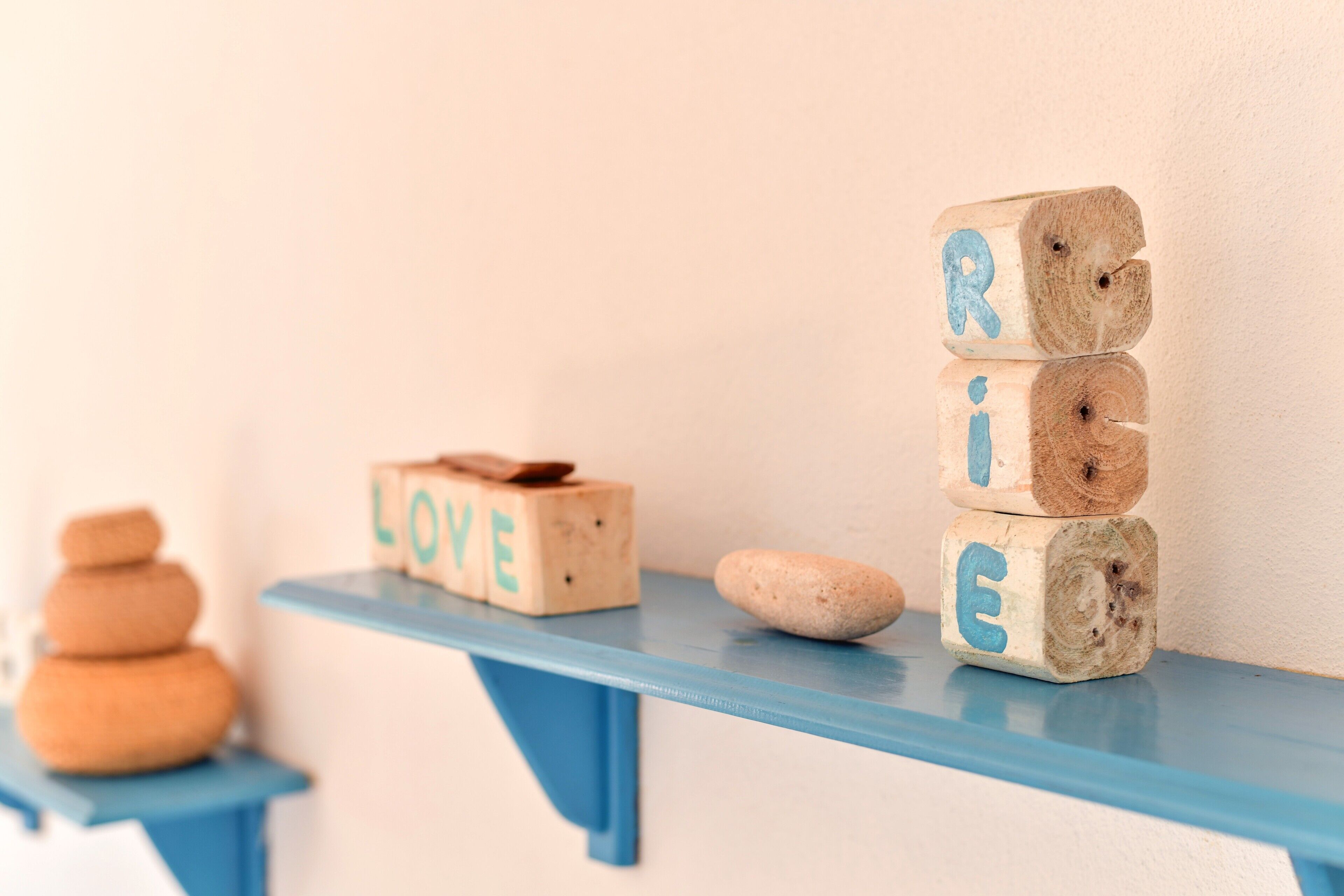 A wooden block with the word 'LOVE' on a shelf.