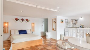 Una camera da letto con un letto, un tavolo da pranzo e un angolo cottura con un forno a microonde.