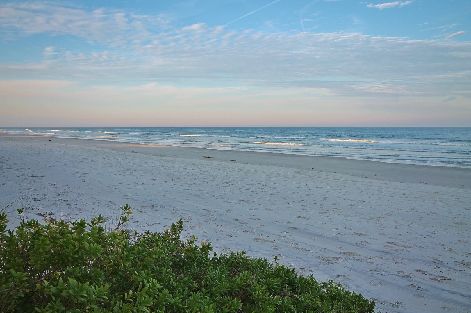 Ein Strand mit blauem Himmel und ruhiger See.