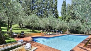 A swimming pool with lounge chairs and a sunbed, surrounded by trees and a grassy area. - Elegant 3 bedroom apt, in historical Villa, shared pool, parking, 3km to Center (Florence)