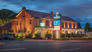 A brick building with a sign for Weintworth Hotel, a parking sign, and a VIP Lounge sign. - Wentworth Hotel (Homebush)