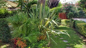Um jardim bem cuidado, com diversas plantas e uma cerca de madeira.