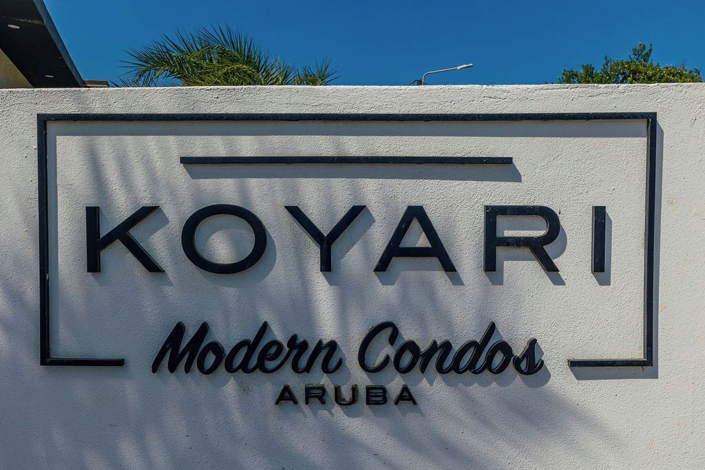 A sign for "Koyari Modern Condos Aruba" with a clear, bold font and a simple rectangular border.