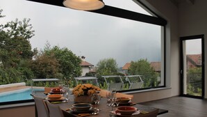 A dining area with a table set for four, overlooking a swimming pool and a garden. - Villa Vittoria - POOL  (Colico Piano)