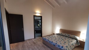 A bedroom with a bed, a door, and a light fixture. - Villa Vittoria - POOL  (Colico Piano)