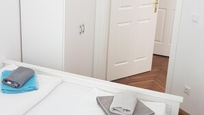 Una camera da letto con un letto, un armadio e una porta che dà su un'altra stanza.