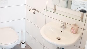 Un bagno con WC, lavandino e doccia.