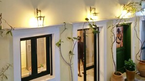 Un bâtiment doté de nombreuses fenêtres, d’une porte et de plantes en pot.