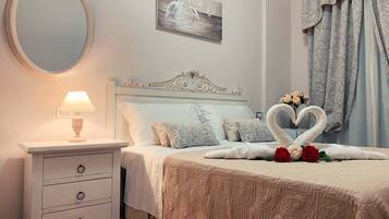 Ein Schlafzimmer mit einem Bett, einem Nachttisch mit Lampe, einem Spiegel und einem Bild an der Wand.