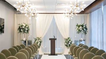 A wedding ceremony setup with a podium, rows of chairs, and floral decorations.