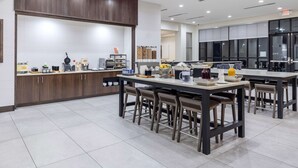 A modern kitchen with a central island, bar stools, and a coffee station. - Hilton Garden Inn Detroit Utica (Clinton Township)