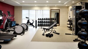 A gym with treadmills, stationary bikes, dumbbells, and weight machines. - Home2 Suites by Hilton Fishers Indianapolis Northeast, IN (Fishers)