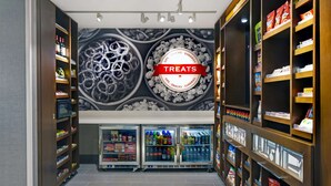 A store with shelves stocked with snacks and drinks, and a 'Treats' sign on the wall. - Hampton Inn Las Vegas Strip South, NV (Las Vegas)