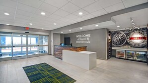A modern reception area with a reception desk, a welcome sign, and a snack display. - Hampton Inn Las Vegas Strip South, NV (Las Vegas)