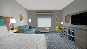 A hotel room with a large bed, a desk with a flat-screen TV, a chair, a desk lamp, and a window with a view of the city.