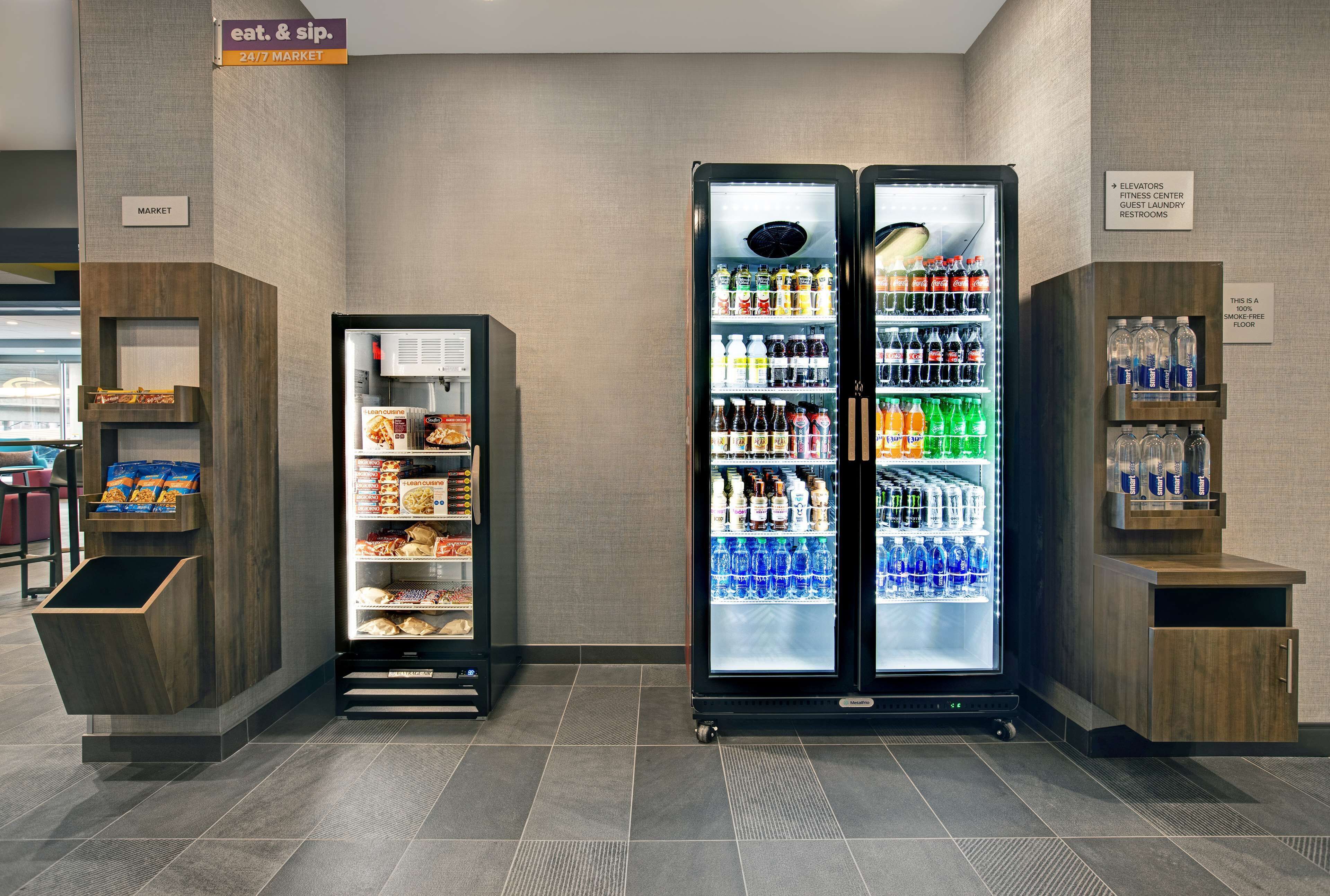 A self-service beverage station with refrigerated drink dispensers and a snack vending machine.