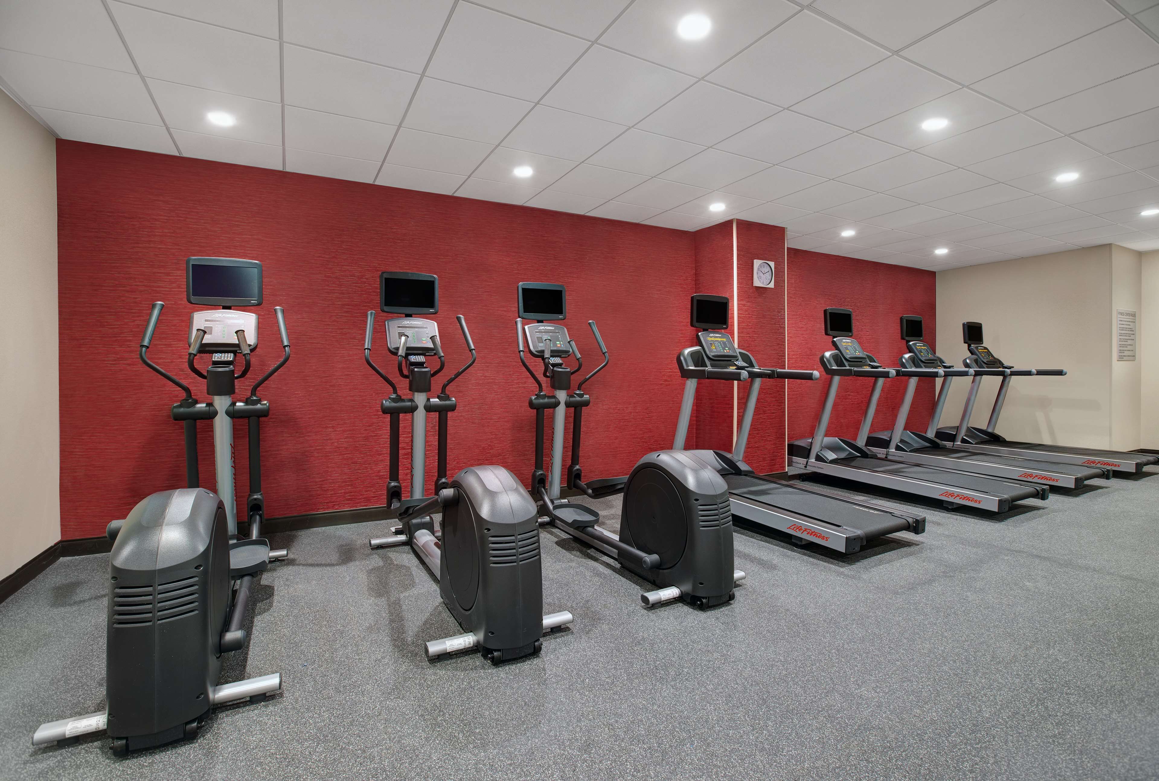 A fitness center with treadmills, elliptical machines, and stationary bikes.