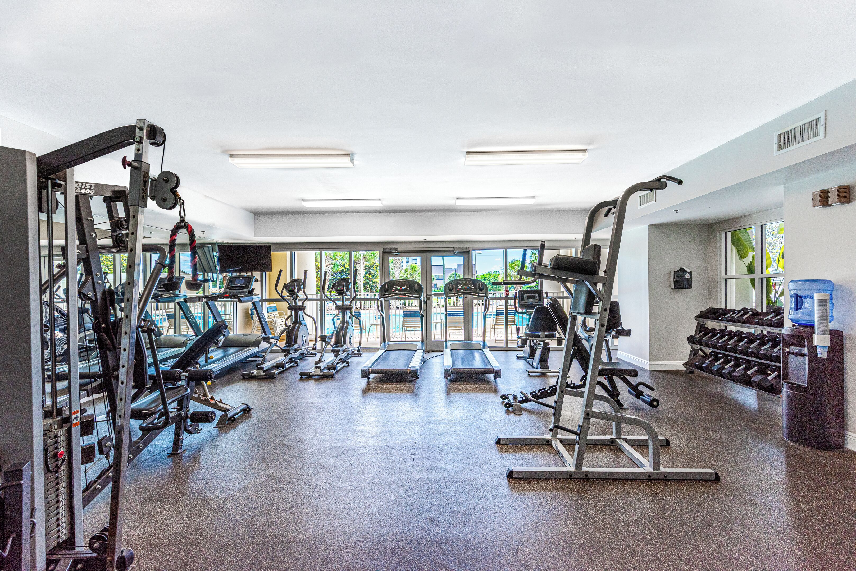 Een fitnessruimte met loopbanden, krachtermaten en gewichten.