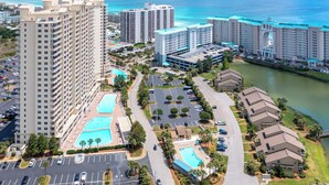 A high-rise hotel with multiple floors, a central courtyard with a swimming pool, and a view of the ocean. - Large Private Balcony ~ Spacious Living Area (Miramar Beach)